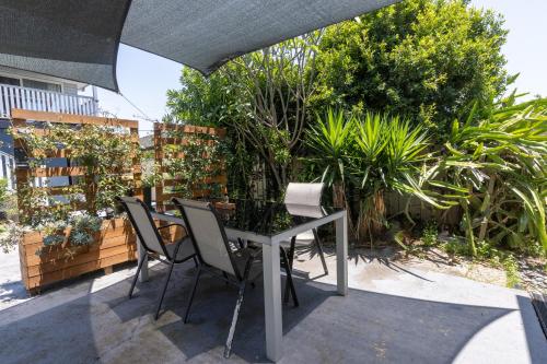 a table and chairs under an umbrella on a patio at Zen Escape Guest House " Location 2" - Zen Garden Tiny Home, Nooky Studio, Chillax Rest in Brisbane