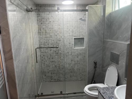 a bathroom with a shower with a toilet at AA inn in Hulhumale