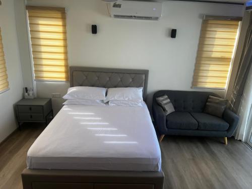 a bedroom with a large bed and a couch at AA inn in Hulhumale