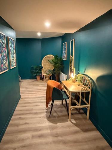 a room with blue walls and a table and a chair at Suite LIANA - SPA- SAUNA in Rorschwihr