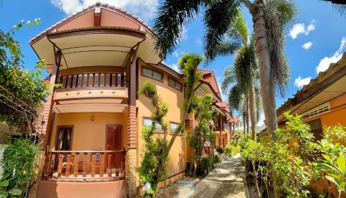 a house with a balcony on a street at Lanta Nature House in Ko Lanta