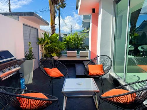 a patio with chairs and a table with orange pillows at Contemporary 3bd Safari Pool Villa Near Nai Yang Beach in Ban Bo Han
