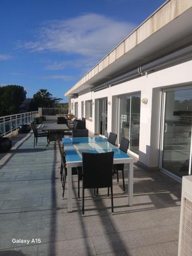 a patio with tables and chairs on a balcony at Appartement Almadrava Roses in Roses