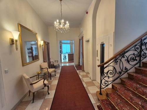 a hallway of a home with stairs and a chandelier at Hotel Beethoven in Frankfurt/Main