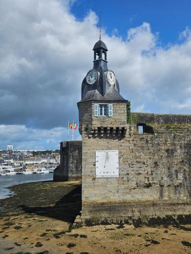 a clock tower on the side of a wall at Studio Le Petit Sablé in Concarneau