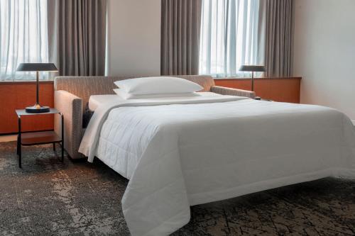 a large white bed in a room with windows at Sheraton Boston Hotel in Boston