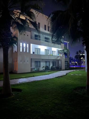 un edificio de noche con palmeras en el primer plano en Résidence hivernage Agadir Bay, beach, pool, proche Sofitel, en Agadir