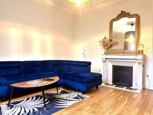 un salon avec un canapé bleu et un miroir dans l'établissement La Duchesse de Bourgogne, à Dijon