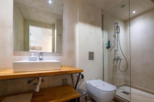 a bathroom with a sink and a shower and a toilet at Panellinion Luxury Rooms in Kalamata
