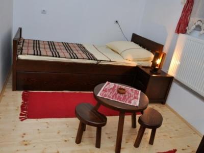 a small room with a bed with a table and stools at Vila Bogdanovic in Kalna