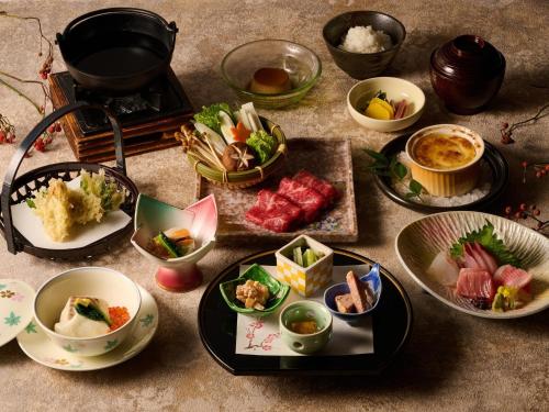 a table topped with plates and bowls of food at Laforet Ito Onsen Yunoniwa in Ito