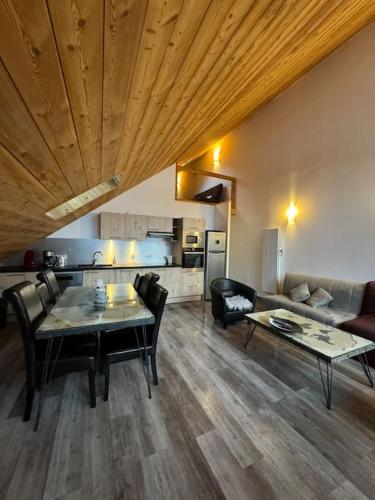 un salon avec une table et des chaises et une cuisine dans l'établissement APT lumineux 8 à 13 pers, au pied des pistes, à La Salle Les Alpes