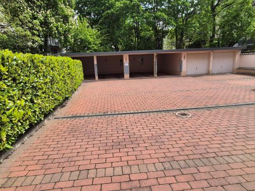 a brick driveway with a building and a hedge at Hotel Beethoven in Frankfurt/Main