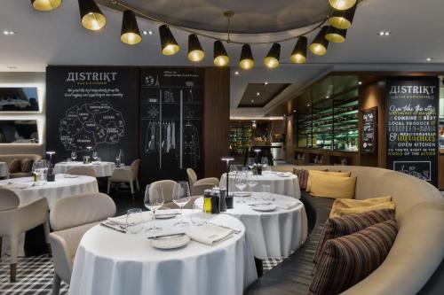 a dining room with white tables and chairs at Skopje Marriott Hotel in Skopje