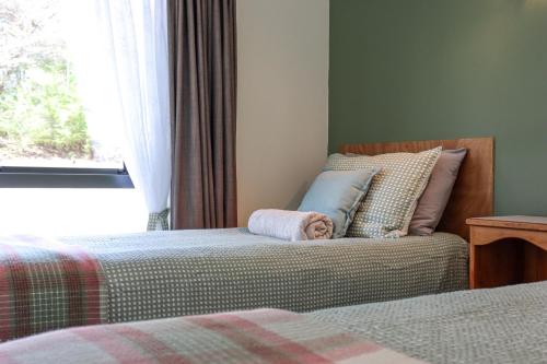 a bedroom with two beds and a window at Kanuka Ridge Lodge in Marahau