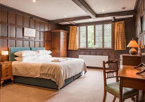 Un dormitorio con una cama, una mesa y un escritorio. en Severn End - 15th Century Manor House!, en Hanley Castle
