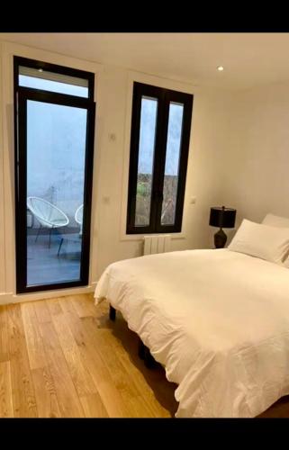 une chambre avec un grand lit et une grande fenêtre dans l'établissement Paris Centre, à Paris