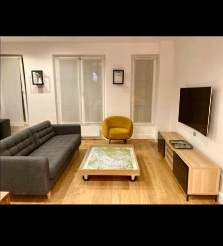 un salon avec un canapé et une chaise jaune dans l'établissement Paris Centre, à Paris