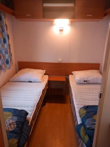 une chambre avec deux lits et une table dans l'établissement la cabanne du pecheur, à Saint-Pierre-dʼOléron