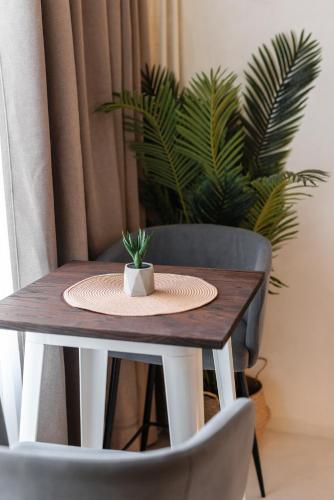 a wooden table with a plate and a plant on it at Marabou Unique Stay in Thessaloniki