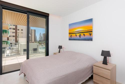 Un dormitorio blanco con una cama y una ventana grande. en Jade Tower - 2-Bedroom Coastal Luxury Apartment in Fuengirola, en Fuengirola
