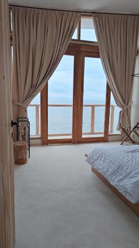 ein Schlafzimmer mit einem Bett mit Blick auf das Meer in der Unterkunft Noosa Dive Resort in Nusa Penida