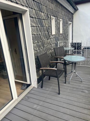 a patio with a table and chairs on a deck at Kurhotel Quellenhof in Bad Bertrich