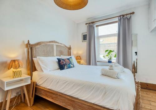 a bedroom with a large white bed with a window at Stylish 2BD with Private Garden and Sauna in Oxford