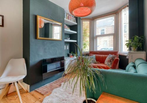 a living room with a blue couch and a chair at Stylish 2BD with Private Garden and Sauna in Oxford