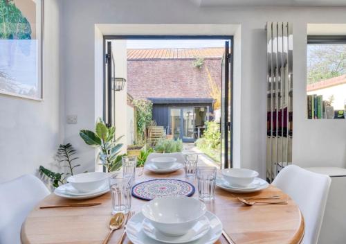 a dining room with a wooden table and chairs at Stylish 2BD with Private Garden and Sauna in Oxford