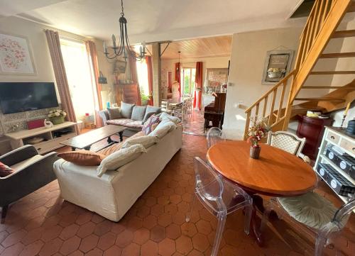 un salon avec un canapé et une table dans l'établissement La maison Villecharny, à Marigny-le-Cahouet