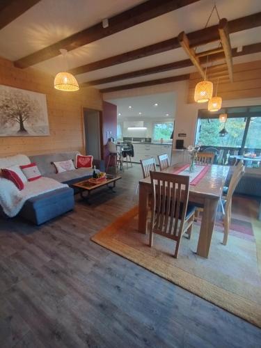 un salon avec une table et un canapé dans l'établissement Chalet au bois des écureuils classé trois étoiles., à Muhlbach-sur-Munster