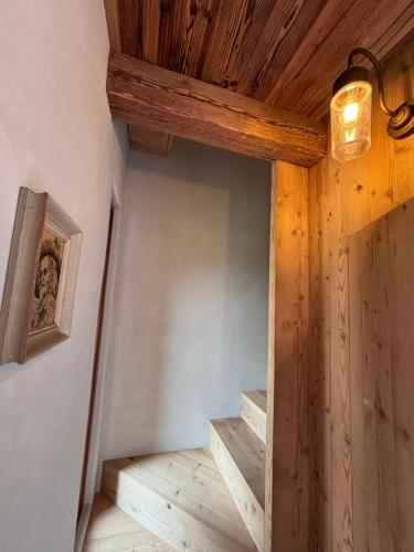a room with stairs and a wooden ceiling at Chalet Valchiavenna in San Cassiano