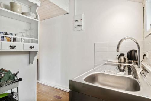a kitchen with a stainless steel sink and white walls at Lovely Holiday Apartment In Rønne in Rønne