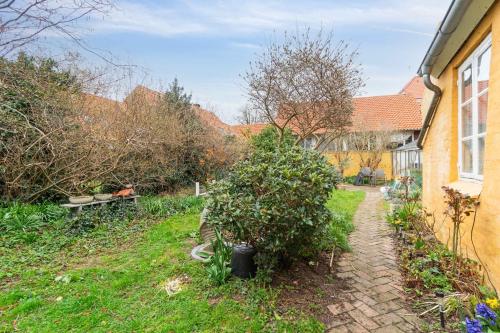 a garden with a brick path next to a house at Lovely Holiday Apartment In Rønne in Rønne