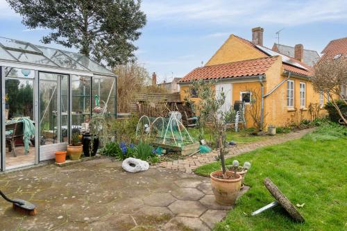 a garden with a greenhouse and a playground at Lovely Holiday Apartment In Rønne in Rønne