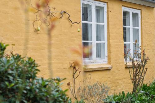 a yellow building with two windows on it at Lovely Holiday Apartment In Rønne in Rønne