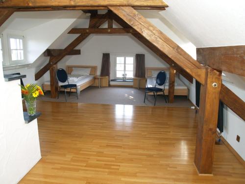 an attic room with a bed and two chairs at Gästehaus Zum Stehling in Monschau