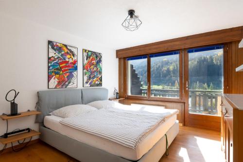 a bedroom with a bed and a large window at Apartment Soleil in Le Châble