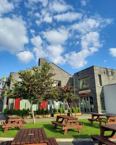 a group of picnic tables in front of a building at Kettles Country House Hotel in Swords