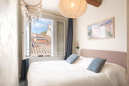 une chambre avec un lit blanc et une fenêtre dans l'établissement Superbe maison avec piscine en plein cœur du village, au Beausset