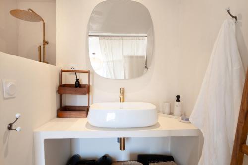 une salle de bain blanche avec un lavabo et un miroir dans l'établissement Superbe maison avec piscine en plein cœur du village, au Beausset