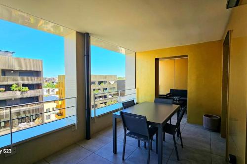 une pièce avec une table et des chaises sur un balcon dans l'établissement Élégant appart à Montpellier Terrasse et parking, à Montpellier