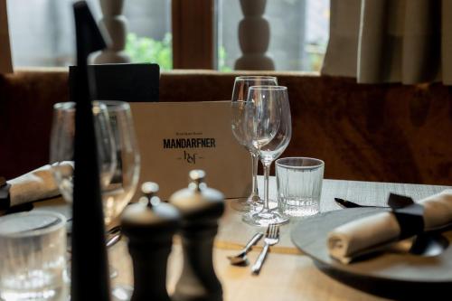 a table with wine glasses and a plate on it at Boutique Hotel Mandarfnerhof in Sankt Leonhard im Pitztal