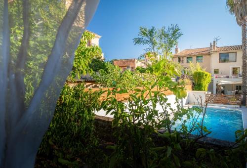 une arrière-cour avec une piscine et des plantes dans l'établissement Superbe maison avec piscine en plein cœur du village, au Beausset