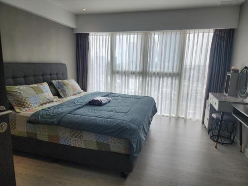 a bedroom with a bed with a blue comforter at 2 BR Apartment Grand Jati Junction Medan view City 12th Floor in Medan