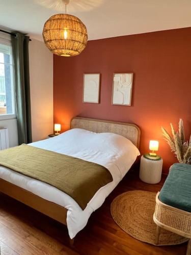 une chambre avec un grand lit aux murs rouges dans l'établissement Maison rénovée haut de gamme de centre-ville, à Saint-Berthevin-sur-Vicoin