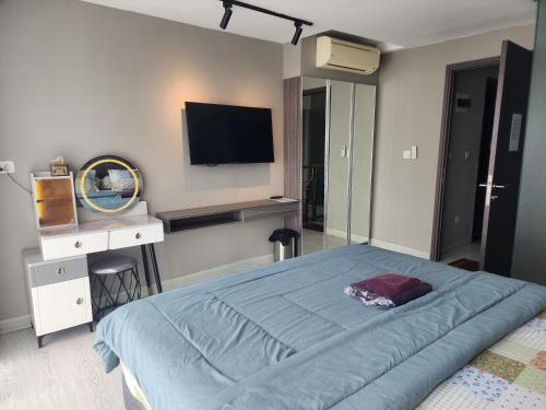 a bedroom with a bed and a television on the wall at 2 BR Apartment Grand Jati Junction Medan view City 12th Floor in Medan