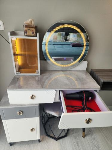 a white dressing table with a mirror and a drawer at 2 BR Apartment Grand Jati Junction Medan view City 12th Floor in Medan