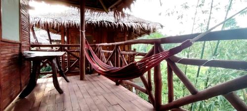a hammock on a porch of a cabin at Dreamer Resort in San Vicente